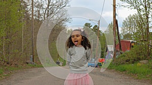 Portrait of girl standing on road against trees