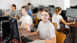 Portrait of girl student looking at camera during lesson in computer class