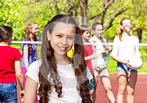 Portrait of girl with teens playing volleyball