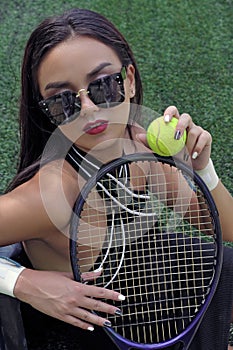 Portrait of a girl with a tennis racket and ball.