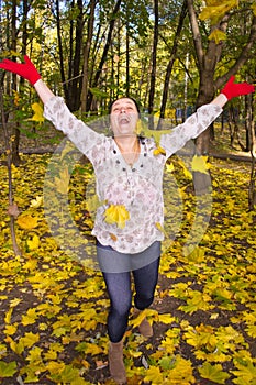 Portrait of a girl throws herself maple leaves