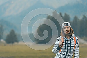 Portrait of a girl traveler on the background of the river and mountains. Travel to the mountains, active and healthy lifestyle