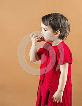 Portrait of a girl using asthma inhaler