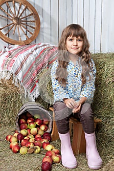 Portrait of girl villager near pail with apples photo