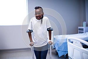 Portrait of girl walking with crutches in ward