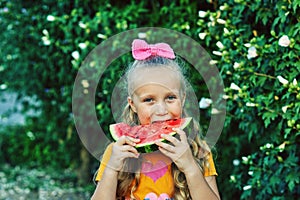 Portrait of a girl with a watermelon in nature