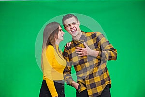 Portrait of girl whispering into man`s ear, telling him something really funny because he is smiling desparately.