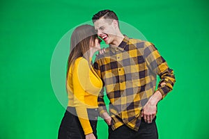 Portrait of girl whispering into man`s ear, telling him something really funny because he is smiling desparately.