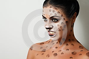 Portrait of a girl on a white background. . face art. body art. hairstyle. black hair. wild cat. growl