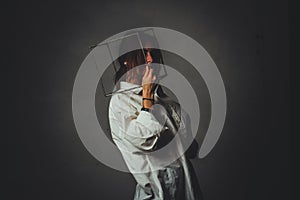 Portrait of a girl in a white shirt with a metal cube-cage on his head. isolate. The concept of estrangement, the man in a case