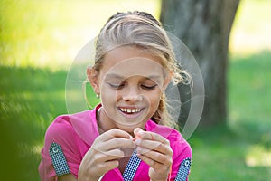 Portrait of a girl who knits on a knitting needles on a picnic in nature, close-up