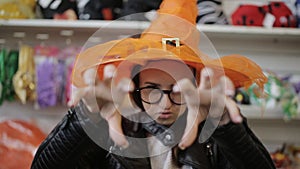 Portrait of a girl in witch`s hat in a Christmas shopping Mall.