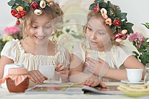 Portrait of girls reading magazine, and drinking tea