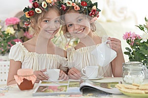 Portrait of girls reading magazine, and drinking tea