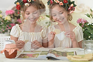 Portrait of girls reading magazine, and drinking tea