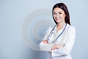 Portrait of glad smiling doctor in white uniform standing with c