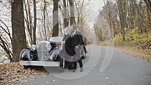 Portrait of glamorous couple in love posing in embraces at car