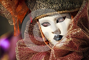 Portrait of a glamorous and seductive woman with beautiful eyes and venetian mask during venice carnival