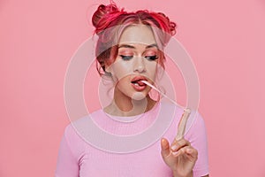 Portrait of glamorous young woman with colored hair stretching chewing gum