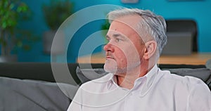 Portrait of gloomy mature 60s gray haired man posing at home or retirement house. Old