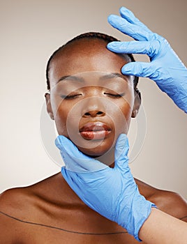 Portrait, gloves and plastic surgery on face of a black woman in studio on a gray background for cosmetic change