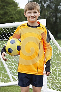 Portrait Of Goal Keeper Holding Ball On School Soccer Pitch