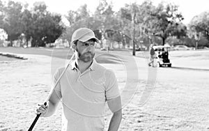 portrait of golfer in cap with golf club looking away. people lifestyle. man playing game