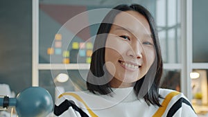 Portrait of good-looking Asian lady office worker smiling in modern office