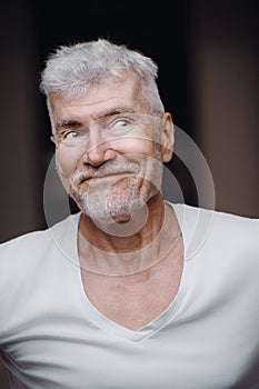 Portrait of a good looking gray haired senior man in white t shirt. Sport and health care concept