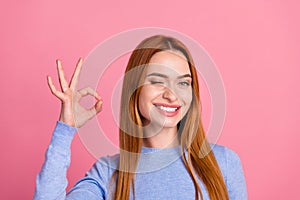 Portrait of good mood girl with foxy hairdo wear blue pullover winking eye show okey approve quality isolated on pink