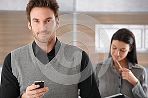 Portrait of goodlooking businessman with mobile