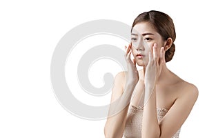 Portrait of a gorgeous Asian woman touches her face concerned about dark spot, freckles, melasma, pimples on her face isolated on