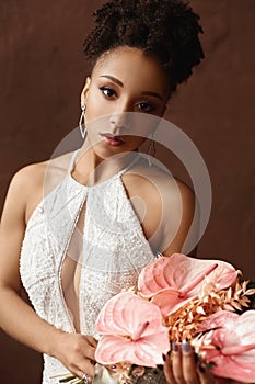 Portrait of gorgeous beautiful African American young woman in fashionable dress. African model girl with a bouquet of