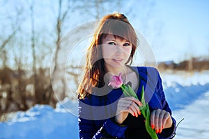 Portrait of a gorgeous beautiful girl in nature in the spring with a Tulip in her hands