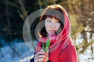 Portrait of a gorgeous beautiful girl in nature in the spring with a Tulip in her hands