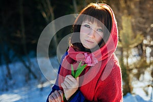 Portrait of a gorgeous beautiful girl in nature in the spring with a Tulip in her hands