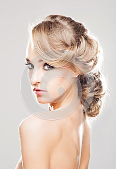 Portrait of gorgeous blond with a beautiful hair style on a grey