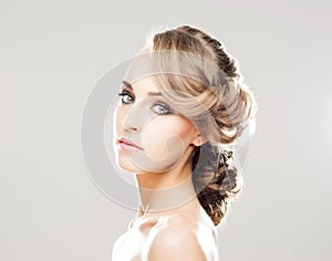 Portrait of gorgeous blond with a beautiful hair style on a grey background.