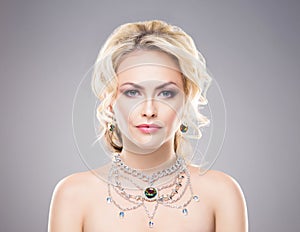 Portrait of gorgeous blond wearing luxury necklace with a gem