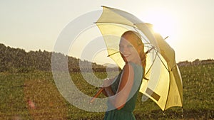 PORTRAIT: Gorgeous blonde woman in a green sundress smiles over her shoulder.