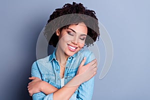 Portrait of gorgeous cheerful girl closed eyes toothy smile hands hug shoulders isolated on grey color background