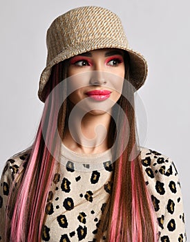 Portrait of gorgeous flirty smiling woman with colored hair wearing leopard pattern print pullover sweater and hat