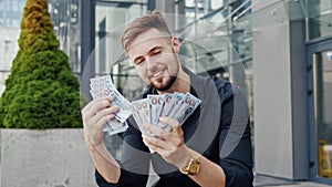Portrait gorgeous happy business man counting money at street outdoor.