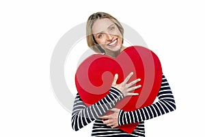 Portrait of a gorgeous smiling young woman holding red heart