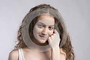 Portrait of a gorgeous teenage girl with curly hair. Studio shot, white background with copy space