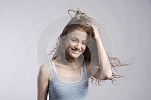 Portrait of a gorgeous teenage girl with curly hair. Studio shot, white background with copy space photo