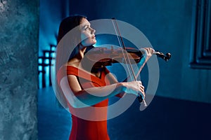 Portrait of gorgeous woman violinist playing beautiful music