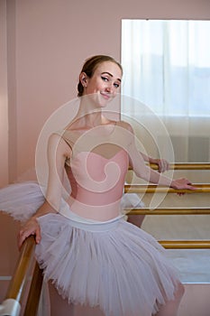 Portrait of a graceful ballerina in a white tutu in a dance class.