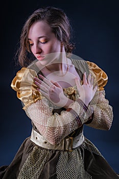 Portrait of graceful expressive girl with lowered eyes in vintage dress