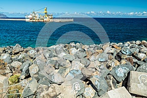 Portrait graffiti art of famous artists, musicians and singers on stones of breakwater in the Santa Cruz de Tenerife. Editorial